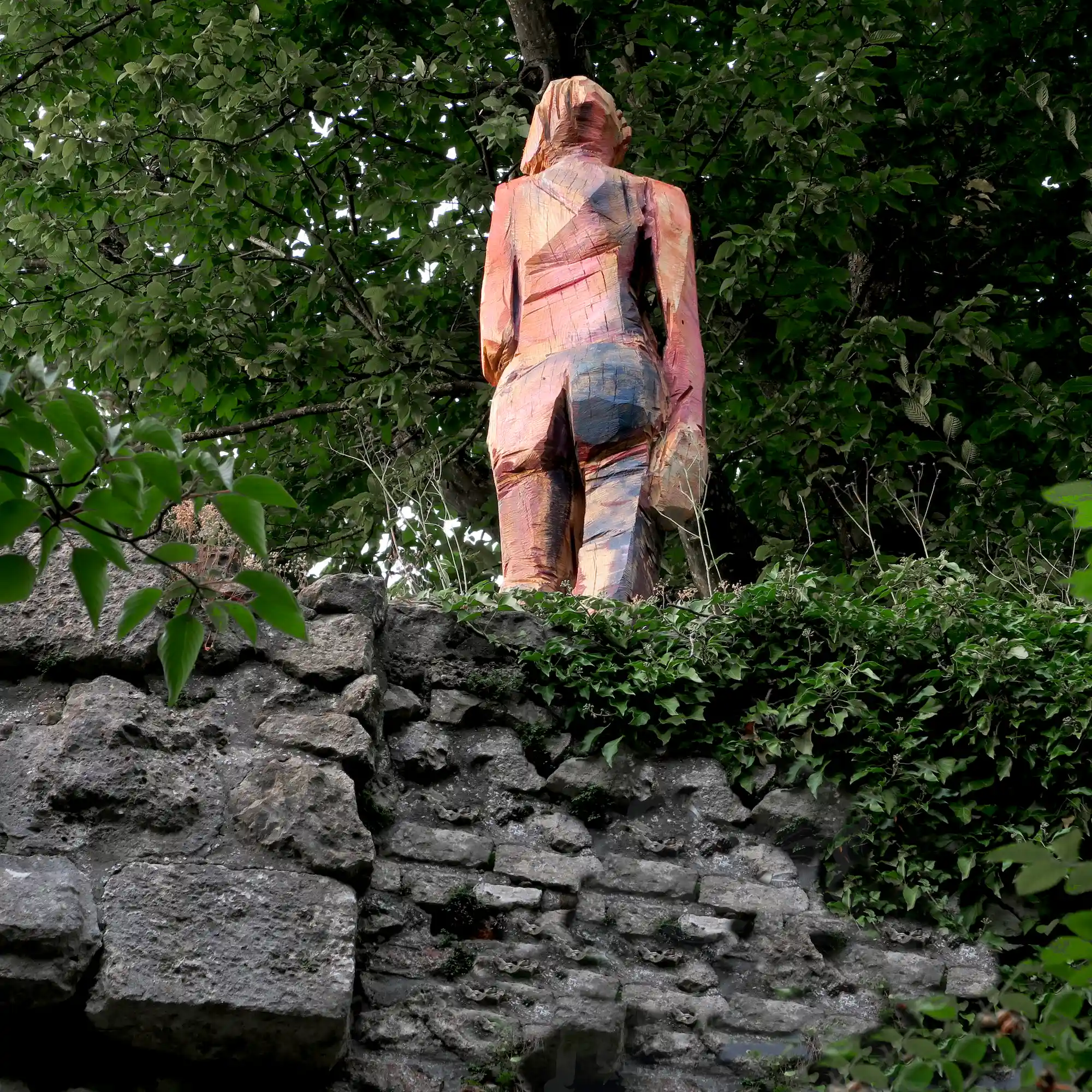 große Holzskulptur 'Davina' auf der alten Mauer im Schlossgarten - Ansicht von hinten