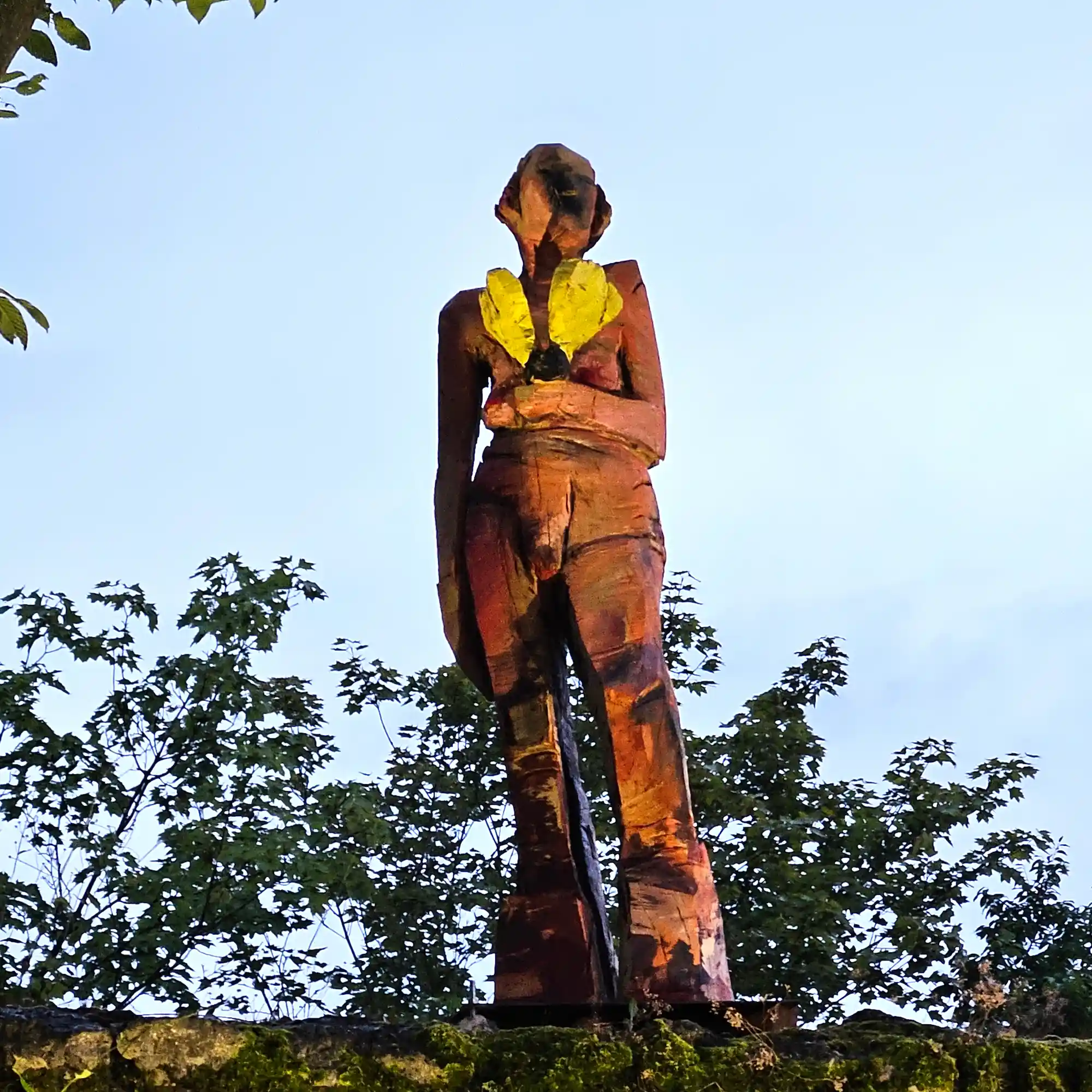 Holzskulptur 'Davina' nach der Enthüllung auf der alten Stadtmauer im Schlossgarten Abensberg im Abendlicht
