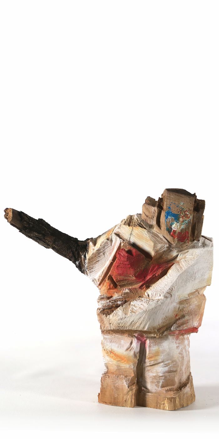 Ausdrucksstarke, bunte Holzskulptur 'Marianne' als Symbol für weibliche Stärke, mit entblößter Brust und fordernd ausgestrecktem Arm aus einem Ast.