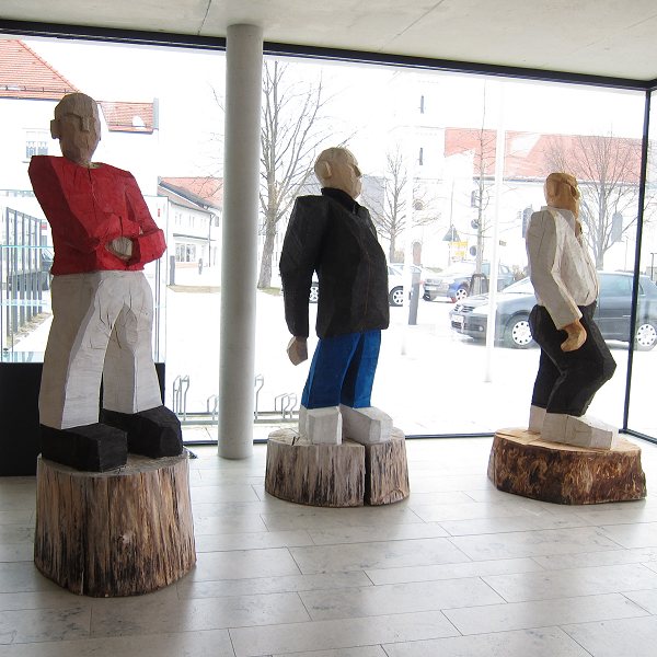 lebensgroße Holzfiguren auf Sockeln - mit der Kettensäge geschnitzt - mit Kleidung