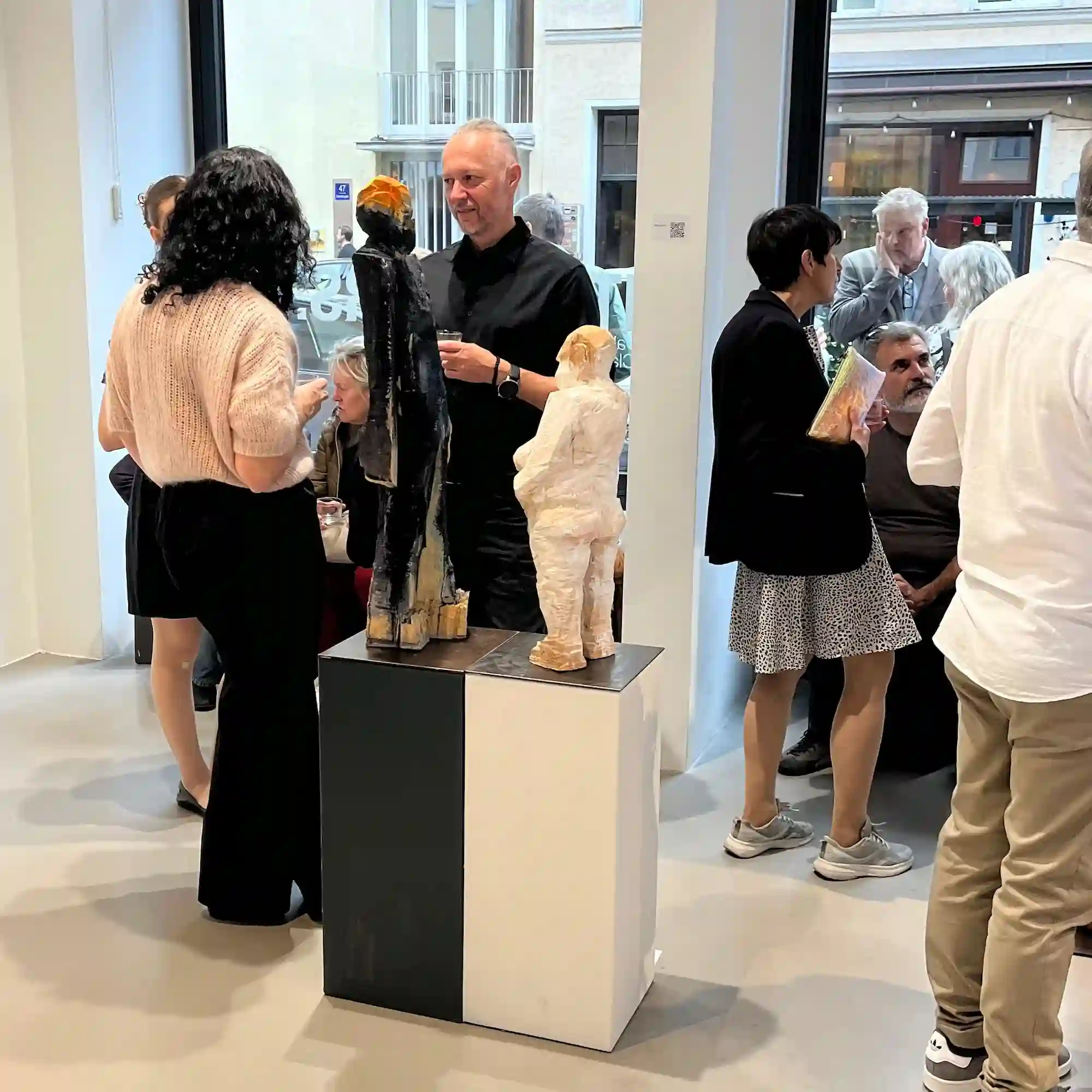 Künstler und Bildhauer Klaus Schwendner im Gespräch mit einer Besucherin in der Galerie konsum163 in München